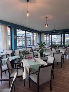 a dining room with tables and chairs and windows at Hotel Pljevlja in Pljevlja