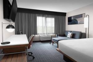 a hotel room with a bed and a desk at Courtyard by Marriott Portland Tigard in Tigard