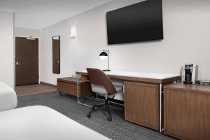 a hotel room with a desk and a television on a wall at Courtyard by Marriott Portland Tigard in Tigard +55 photos