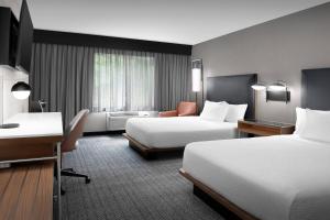 a hotel room with two beds and a desk at Courtyard by Marriott Portland Tigard in Tigard