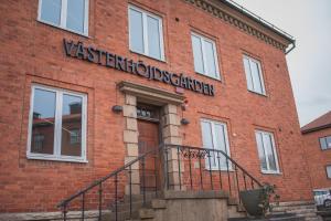 a red brick building with a sign on it at Västerhöjdsgården in Skövde