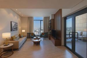 a living room with a couch and a tv at Radisson Collection Residences, Riyadh in Riyadh