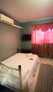 a bedroom with a bed and a red curtain at Triple K Complex in Kelly Village