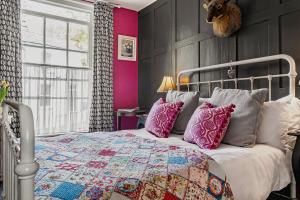 a bedroom with a bed with a quilt and pillows at One Drake Road Hotel in Tavistock