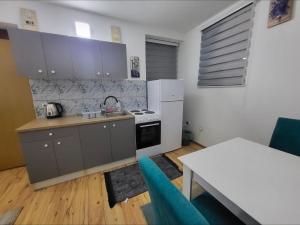 a kitchen with a stove and a white refrigerator at Lira Apartmani in Prnjavor