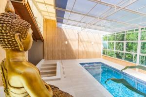 a pool with a statue of a mermaid in a room at Hotel Morada Del Este in Canoas