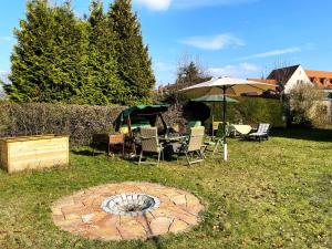a patio with chairs and an umbrella and a fire pit at Villa Seenswert in Lauta