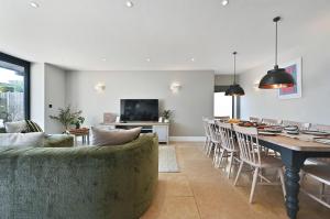 a living room and dining room with a couch and a table at Xanadune Beach House by Bloom Stays in Greatstone