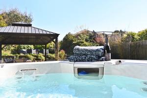 a chair sitting in a hot tub with a bottle of wine at Xanadune Beach House by Bloom Stays in Greatstone