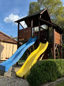 a playground with two slides in front of a building at Country House Liptov in Svätý Kríž