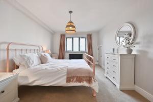 a white bedroom with a bed and a mirror at Xanadune Beach House by Bloom Stays in Greatstone +40 photos