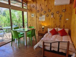 a bedroom with a bed and a table and chairs at Cabañas Carolín Cacao Castaño in San José de Maipo