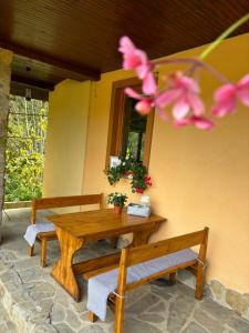 a wooden table and benches on a patio with pink flowers at Country House Liptov in Svätý Kríž +46 photos