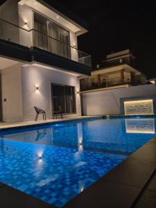 a swimming pool in front of a house at night at Exotica Stays in Alibaug