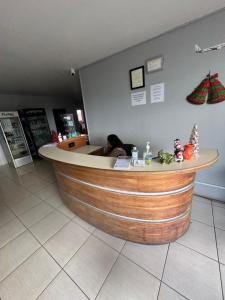 a bar in a restaurant with a woman sitting at a counter at Triple K Complex in Kelly Village