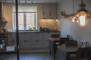 a kitchen with white cabinets and a table and a window at Västerhöjdsgården in Skövde