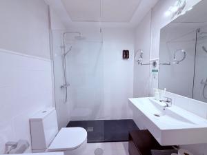 a white bathroom with a toilet and a sink at Smartmonki Sinagoga entre la Catedral y Zocodover in Toledo +105 photos