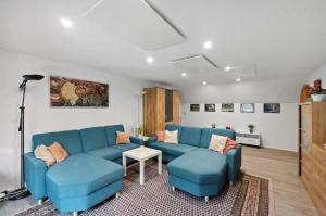 a living room with blue couches and a table at Haus am Scheibenfelsen in St. Blasien