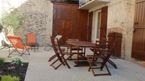a wooden table and chairs on a patio at Entre pierre & vigne in Arrentières