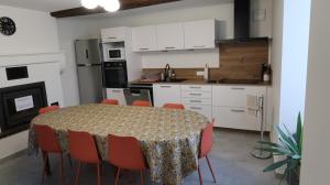 a kitchen with a table and chairs in a room at Entre pierre & vigne in Arrentières