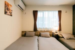a bedroom with two beds and a window at ステラガーデン in Kami-furano