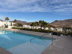 a swimming pool with palm trees and mountains in the background at Casa Almar in San José