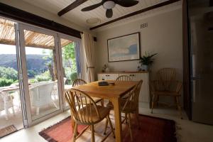 a dining room with a wooden table and chairs at Featherwood Cottage in Malgas