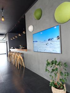 a restaurant with a tv on the wall and a bar at Hótel Laxá in Myvatn