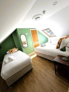 two beds in a room with green and white at Westport Rooms in Westport +12 photos