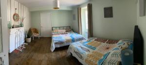 a bedroom with two beds and a dog in it at Au Cœur de Charroux in Charroux