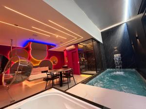a room with a pool and a table and a couch at Ouro Motel in Sepetiba