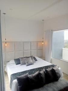 a bedroom with a large bed and a window at Mirador samsara Jacuzzi al aire libre 60 m2 in La Calera