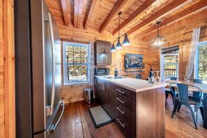 a kitchen with a refrigerator and a table with chairs at Le Sherwood #4 Shannon in Valcartier Station