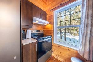a small kitchen with a stove and a window at Le Sherwood #4 Shannon in Valcartier Station