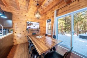 a dining room with a wooden table and a large window at Le Sherwood #4 Shannon in Valcartier Station