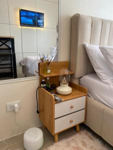 a bedroom with a nightstand with a bed and a mirror at Casa Ona in Manila