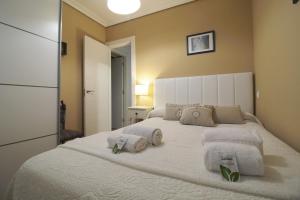 ein Schlafzimmer mit einem großen weißen Bett, auf dem Handtücher liegen in der Unterkunft Comillas playa in Comillas