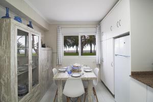 ein Esszimmer mit Tisch und Stühlen und eine Küche in der Unterkunft Comillas playa in Comillas