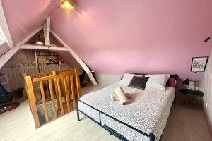 a bedroom with pink walls and a bed with a crib at Escapade détente Duplex cosy avec SPA Parking in Abbeville +14 photos