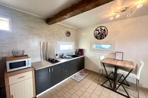 a kitchen with a table and a microwave at Escapade détente Duplex cosy avec SPA Parking in Abbeville