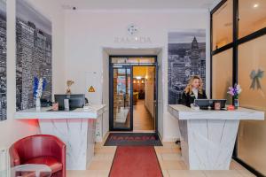 a woman sitting at a counter in a coffee shop at Ramada by Wyndham Frankfurt Central Station in Frankfurt