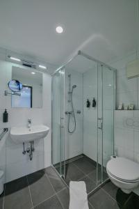 a bathroom with a shower and a toilet and a sink at Ramada by Wyndham Frankfurt Central Station in Frankfurt +68 photos