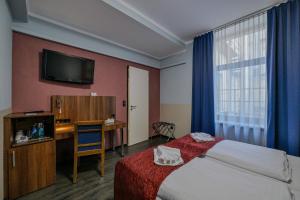 a hotel room with a bed and a television at Ramada by Wyndham Frankfurt Central Station in Frankfurt