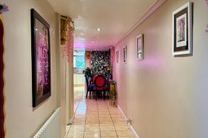 a hallway with pink walls and a table and chairs at 1 Bed Flat - Sleeps 5 - Pet friendly - Parking in South Shields +17 photos
