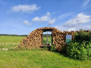 ein aus Brennholz errichtetes Gebäude auf einem Feld in der Unterkunft Biehlerhof in Freudenberg