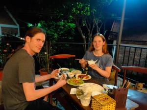 a man and a woman sitting at a table eating food at Son Home Garden in Hue