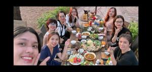 a group of people sitting around a table with food at Son Home Garden in Hue