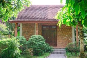 a small brick house with a wooden door at Son Home Garden in Hue