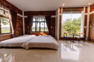 a bedroom with a bed and a brick wall at Son Home Garden in Hue +83 photos