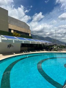 a large blue swimming pool in front of a building at Hotel CCT Caracas in Caracas
